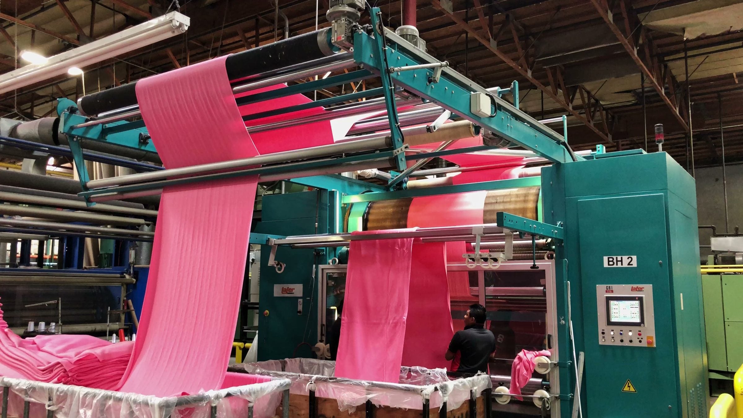 Fabric running through a machine at Los Angeles Apparel